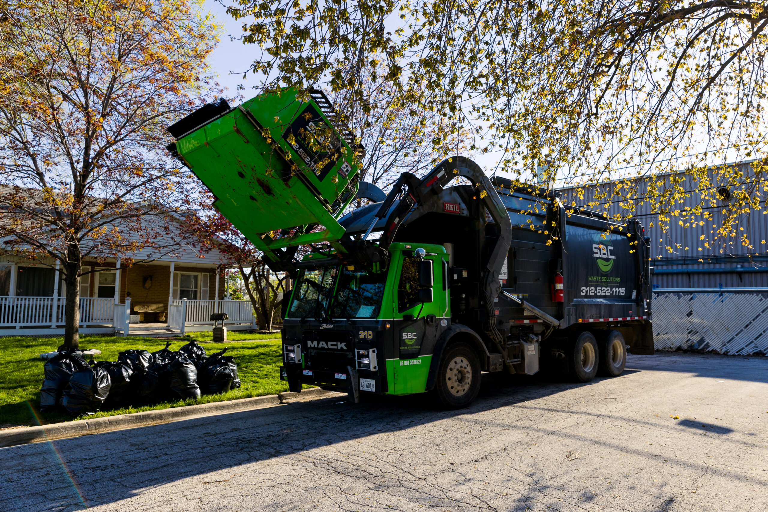 An S.B.C. garbage truck picking up trash at a Bridgeview home.