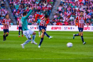 Chivas player kicks ball.