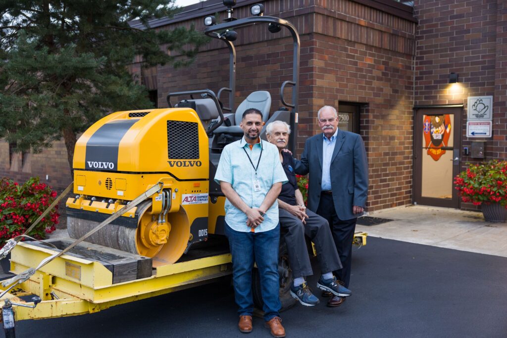 From left to right, Trustee Kalid Baste, Clerk John Altar, & Trustee Gary Lewis stand next to a new Asphalt Roller.