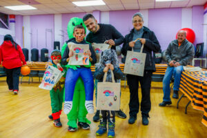 A family stands with their decorated trick-or-treat bags.