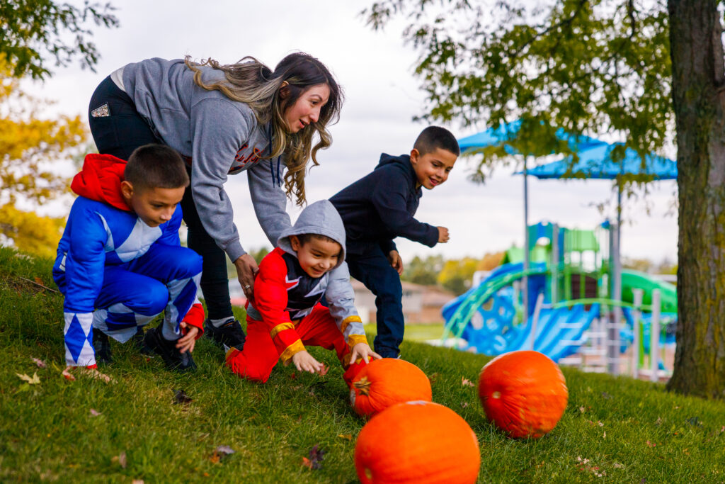 Children roll pumpkins down the hill for the contest.