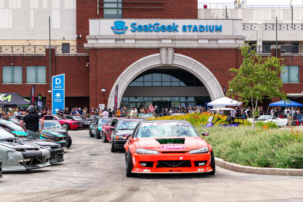 Cars lined up in front of SeatGeek Stadium heading to the drift pit with eager passengers.
