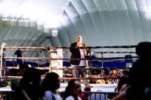 The audience listens as the announcer introduces the next fighters.
